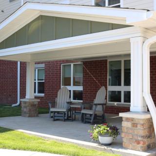A front porch with chairs and a small table.