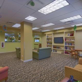 A cozy library reading room with comfortable seating and bookshelves.