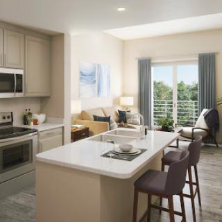 A bright and modern kitchen featuring sleek appliances, an expansive island, and inviting seating area with a view.
