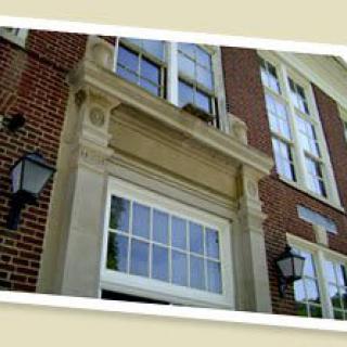 A view of a brick building facade featuring large windows and decorative stonework.