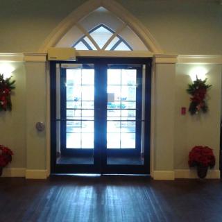 A well-decorated entrance with double doors adorned with holiday decorations and poinsettias.
