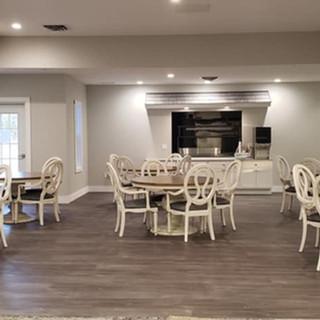 A modern dining area with several tables and chairs set on a hardwood floor.