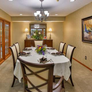 An elegant dining room with a set table, chandelier, and classic decor.