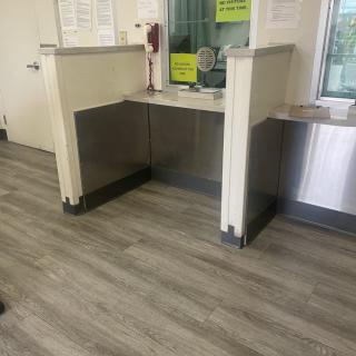 A reception area with a front desk and laminate wood flooring.