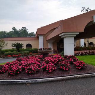 A building with a landscaped garden and vibrant flowers in the foreground.