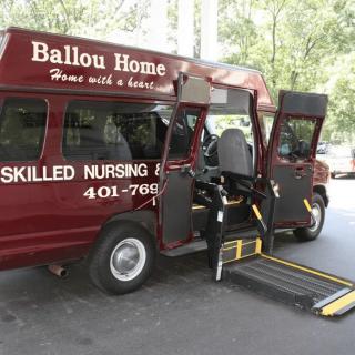 A nursing home van with a wheelchair ramp extended.