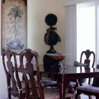 A classic dining room featuring a wooden table and chairs with elegant decor.