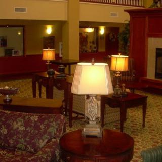 A cozy hotel lobby featuring sofas, tables, and warm lighting.