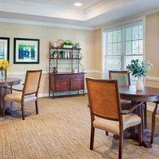 A cozy dining area with wooden tables, upholstered chairs, and decorative elements.