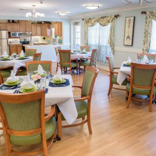 A well-arranged dining area with elegant table settings and a view of the adjacent kitchen.