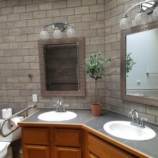 A modern bathroom with dual sinks, mirrors, and stylish lighting.