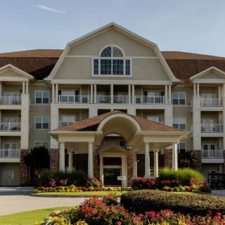 A grand hotel building with a landscaped entrance and elegant architecture.