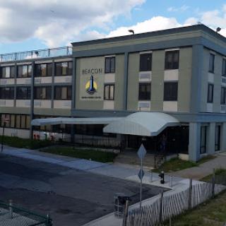 A modern building with a green faade and prominent signage, situated in an urban environment.