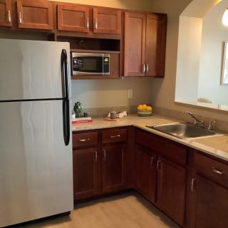 A modern kitchen with stainless steel appliances and wooden cabinets.