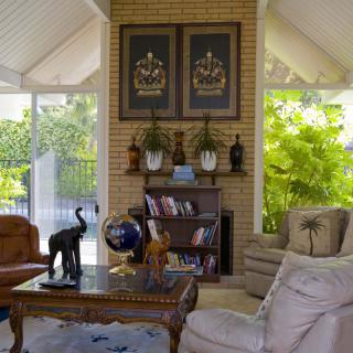 A cozy living room featuring elegant decor with a brick fireplace, art pieces, and comfortable seating.