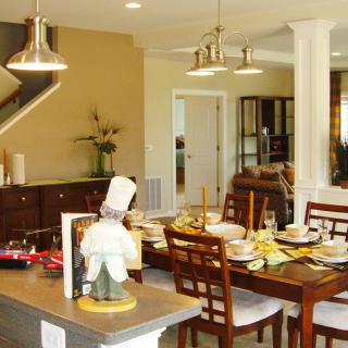 Modern open-concept dining and kitchen area with elegantly set dining table.