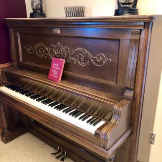 A beautifully crafted vintage piano with intricate detailing and a rich wood finish.
