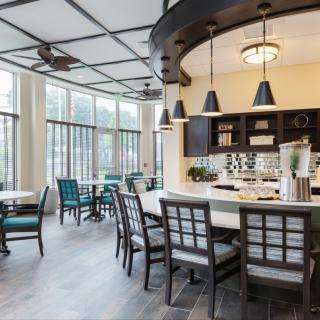 Modern kitchen and dining area with ample natural light and stylish furniture.