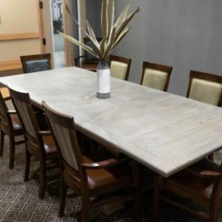 A conference room with a large table and chairs, featuring a decorative vase in the center.