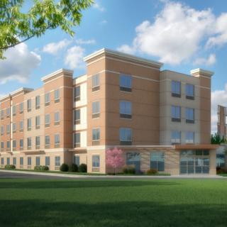 A modern apartment building with a brick facade under a clear blue sky.