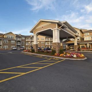 A view of a hotel exterior with a spacious entrance and landscaped surroundings.