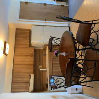 A cozy kitchen with a round dining table and wooden cabinets.