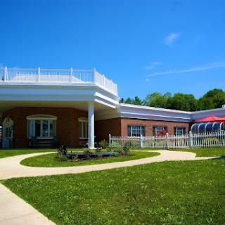 A modern building surrounded by green lawns and a clear blue sky.