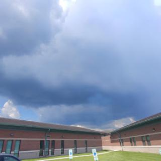 A dramatic sky filled with clouds above a building.
