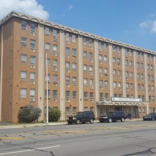 A four-story brick building located on a busy urban street.