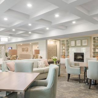 A modern and cozy living room with soft lighting, elegant furniture, and a welcoming fireplace.
