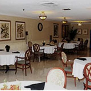A cozy restaurant interior with several tables and chairs arranged in a warmly decorated dining area.