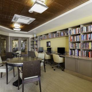 A modern library room with bookshelves, computers, and seating areas.