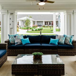 Comfortable wicker patio furniture with blue cushions in an open, spacious outdoor area.