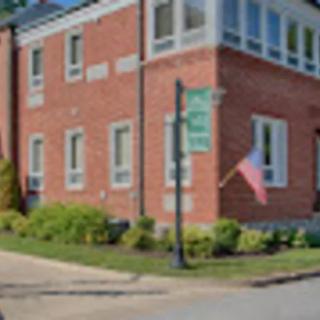 A brick building with a flag on a street corner.