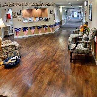 A welcoming reception area in a nursing home with decorated walls and seating.