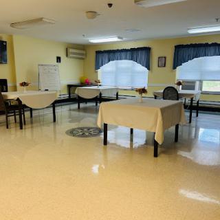 A spacious and well-lit indoor room set up with several tables and chairs.
