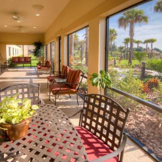 A sunny patio with outdoor seating and a garden view.