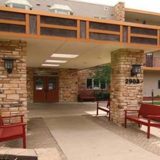 The entrance of a building featuring stone pillars and outdoor benches.