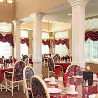 An elegant dining room with red tablecloths and classic decor.