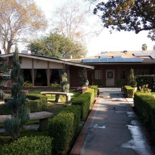 A scenic view of a house surrounded by a neatly landscaped garden with a pathway leading to the entrance.