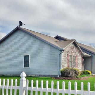 A suburban house with a white picket fence and well-maintained lawn.