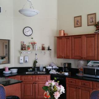 A kitchen interior with wooden cabinets, a countertop, and decorative flowers.