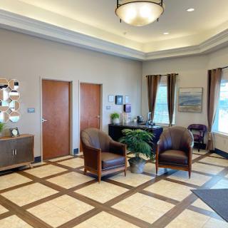 A spacious and inviting lobby with comfortable seating, decorative plants, and elegant lighting.