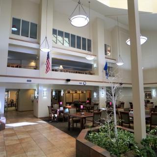 A spacious atrium with dining tables, flags, and ample natural light.