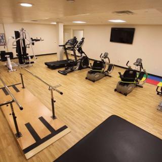 A modern gym with various exercise equipment, including treadmills and stationary bikes.