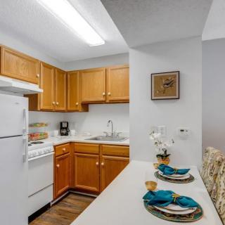 A cozy kitchen with wooden cabinets and a small dining area.