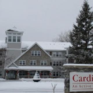 A picturesque assisted living facility covered in snow, showcasing its charming architecture during winter.