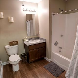 A modern bathroom with a toilet, sink, and bathtub.