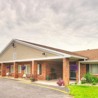A cozy residential building with landscaped gardens under a cloudy sky.