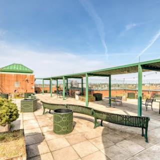 A vibrant rooftop space featuring green benches and a clear blue sky, perfect for relaxation.